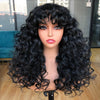 A model wears a long, black curly wave wig with bangs against a blurred background.