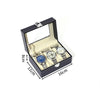 Dunkelgraيبه Lederuhrdisplaybox mit Klappdeckel, der drei Armbanduhren zeigt.