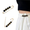 Gold-toned adjustable pearl brooch with black beads used to cinch a white skirt