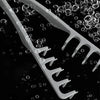 A close-up of a white volume boosting detangling hair comb with numerous small bubbles floating around it.