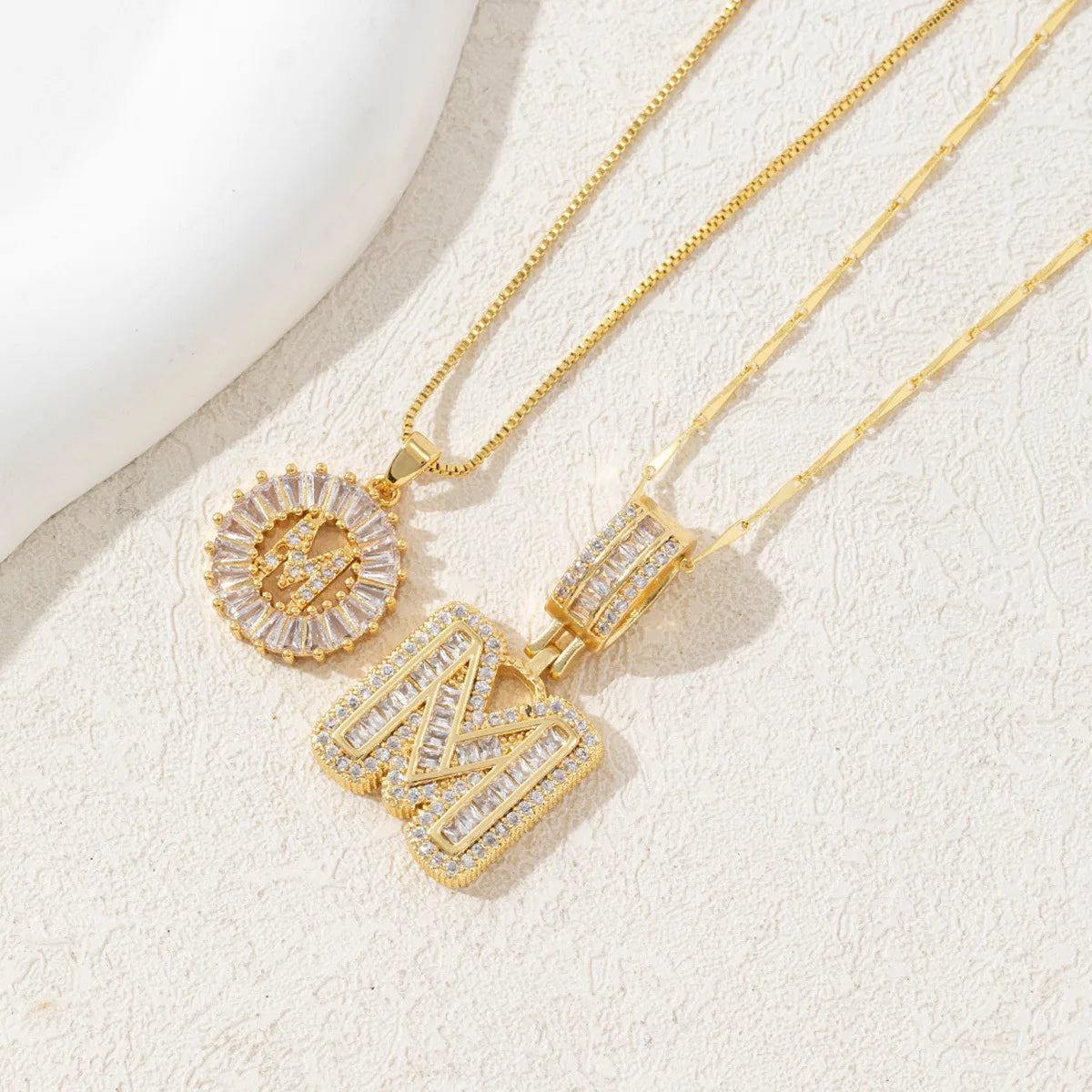 Gold-toned necklace set featuring CZ crystal pendants shaped like the letters I and X.