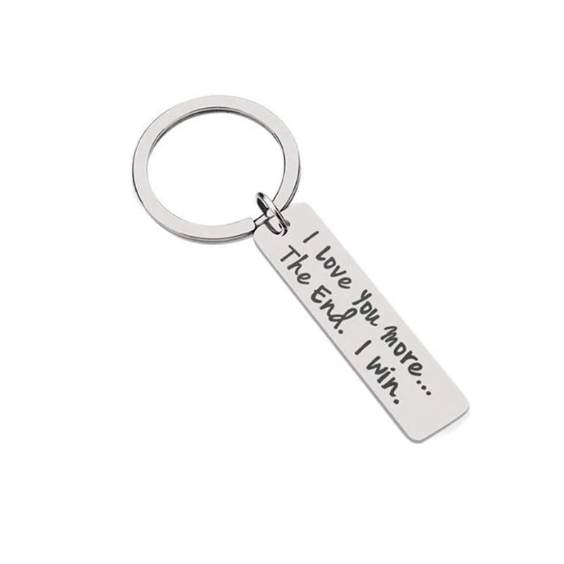 Silver keychain with a circular ring and a tag engraved with the message I Love You more I win.