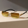 Gold-accented rectangular sunglasses with amber lenses and black frames resting on a white surface.