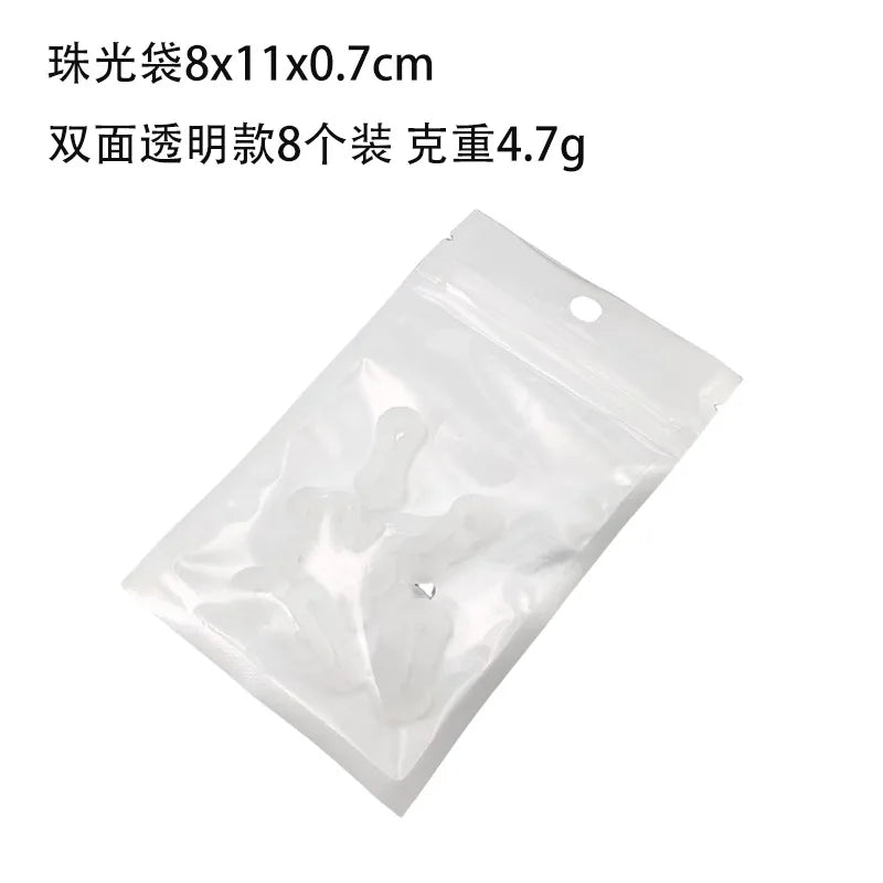 Una bolsa de plástico transparente que contiene ocho hebillas de extensión para mangas de camisa.