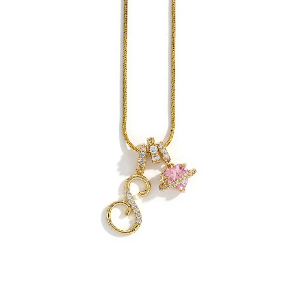 A gold letter S pendant necklace featuring a pink flower charm on a white background.