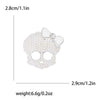 Broche calavera de circonita blanca con detalle de lazo, mide 2.8cm y pesa 6.6g.