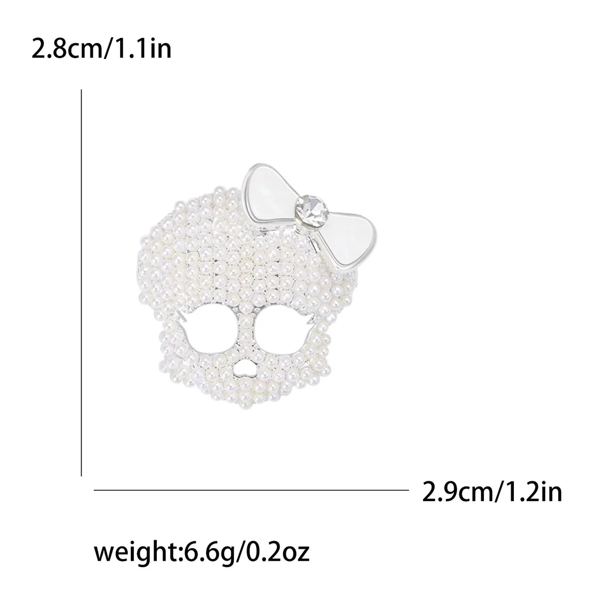 Broche calavera de circonita blanca con detalle de lazo, mide 2.8cm y pesa 6.6g.