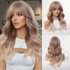 A model showcases a long, wavy sandy blonde wig with bangs and a white top.