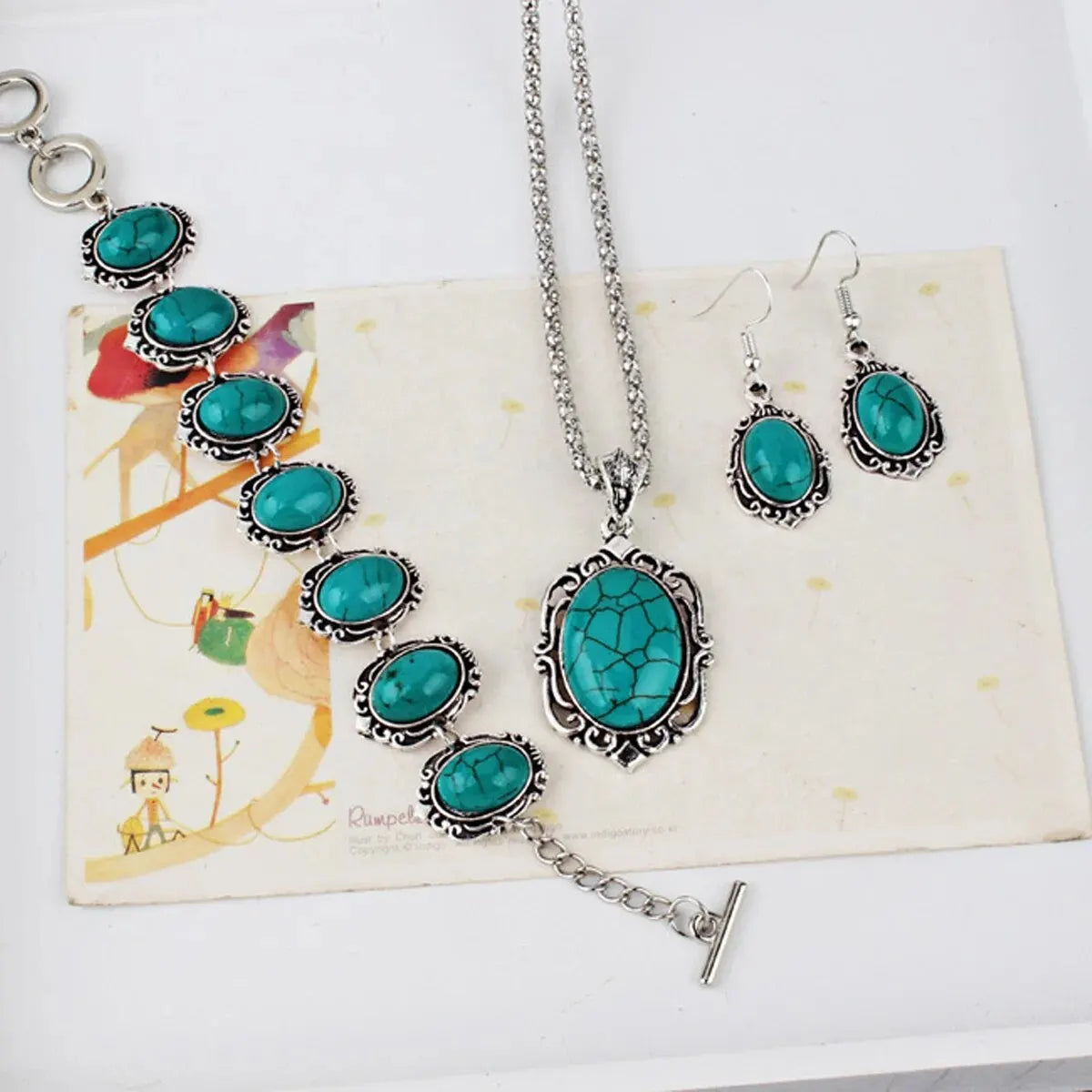 Silver turquoise stone jewelry set featuring a necklace and matching earrings displayed on a light background.