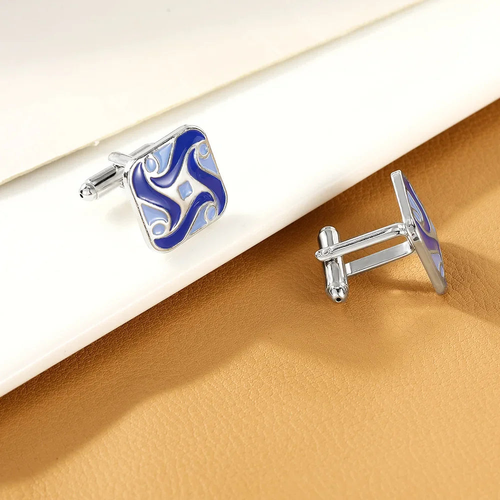 Pince-cuffs argentés avec émail rayé bleu et blanc sur fond beige.