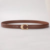 A brown leather belt with a gold C-shaped buckle lying flat on a white surface.