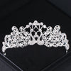 Tiare et couronne en strass de cristal argenté, accessoire pour les cheveux, sur une surface sombre.