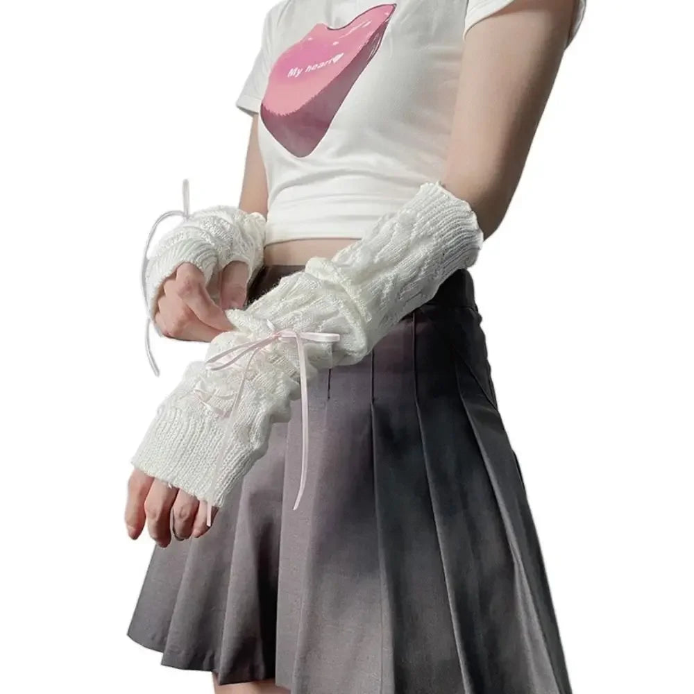 A person wearing white fingerless arm warmers and a light gray skirt, with a white t-shirt featuring a pink lip design.