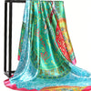 A vibrant teal and pink silk square scarf draped over a black metal hanger.