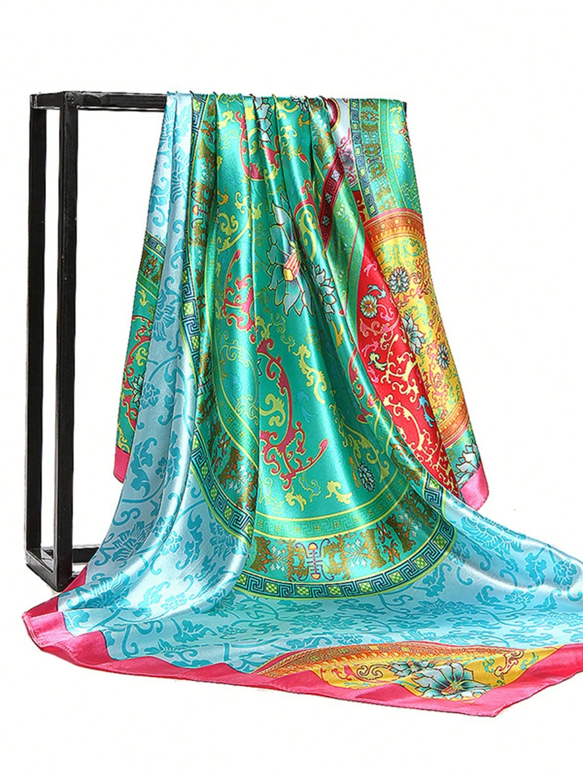 A vibrant teal and pink silk square scarf draped over a black metal hanger.