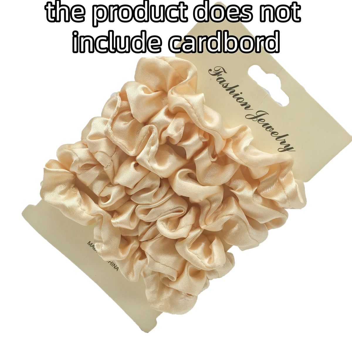 A pile of light pink satin hair scrunchies displayed on a cardboard tag.