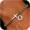 A close-up of a personalized stainless steel cross Cuban chain bracelet worn on a wrist.