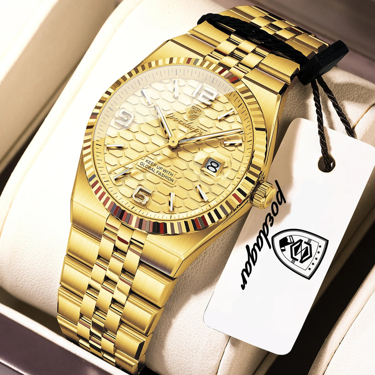 A gold-toned luxury quartz wristwatch with a gold bracelet and black strap is displayed in a light-colored box.