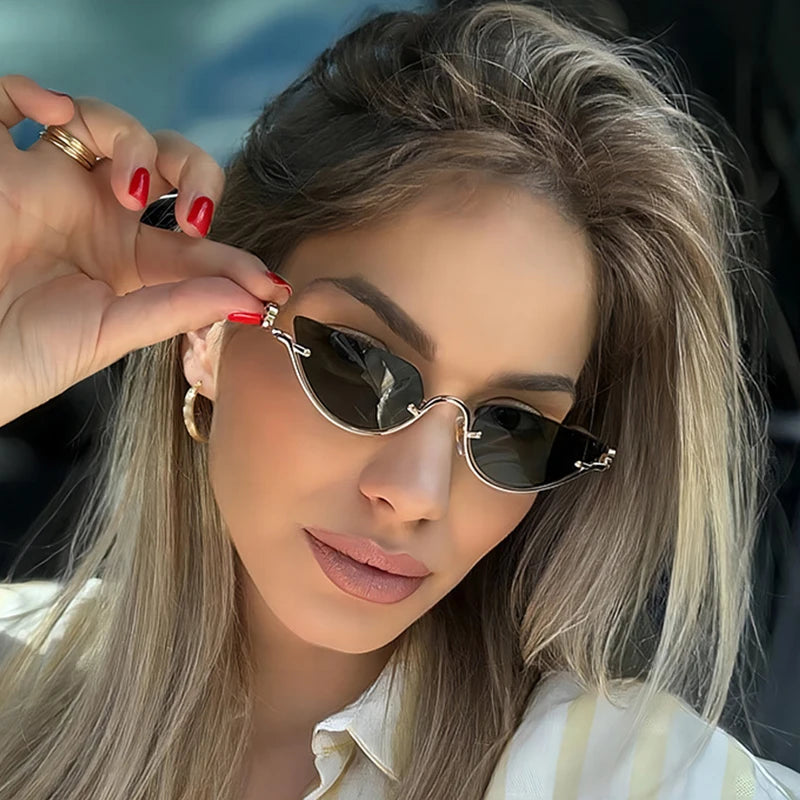 Una mujer modela gafas de gato metálicas retro con cabello rubio largo y uñas rojas.