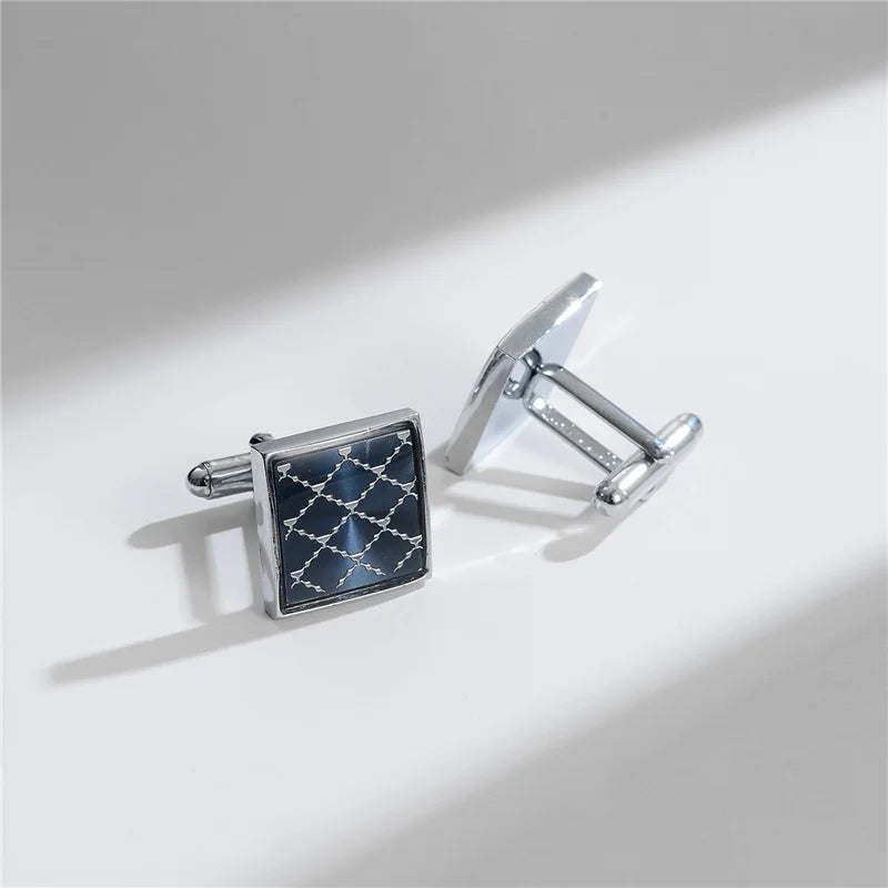 Silver cufflinks featuring a square, dark blue patterned stone set against a silver metal frame.