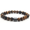 A bracelet made of polished tiger eye stones and a silver-colored bar.