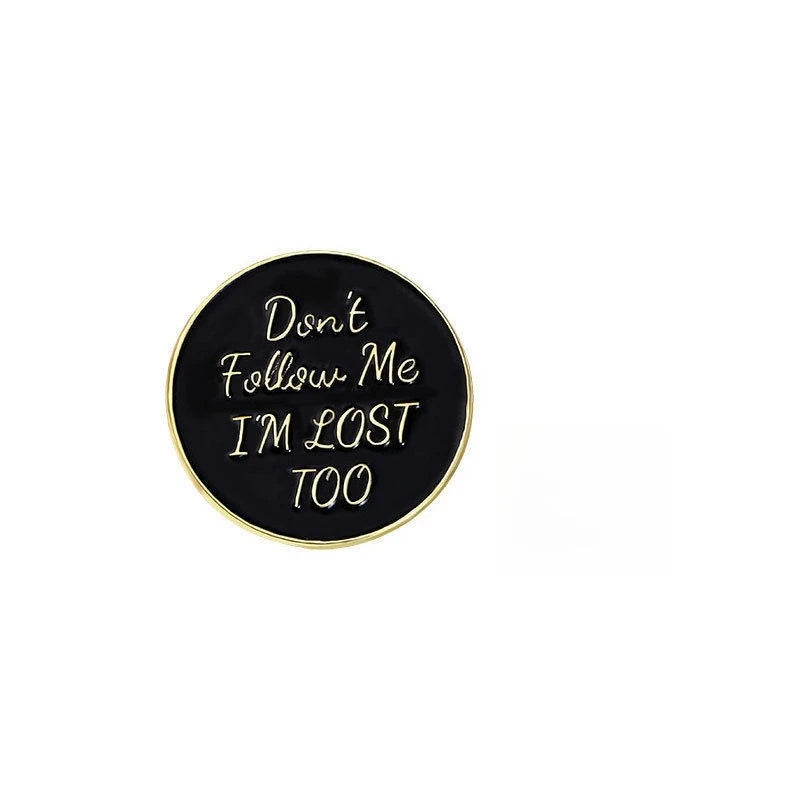 A black lapel pin with the text Don't Follow Me I'm Lost Too engraved on it.