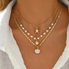 Gold layered necklace featuring a starfish pendant and pearl beads