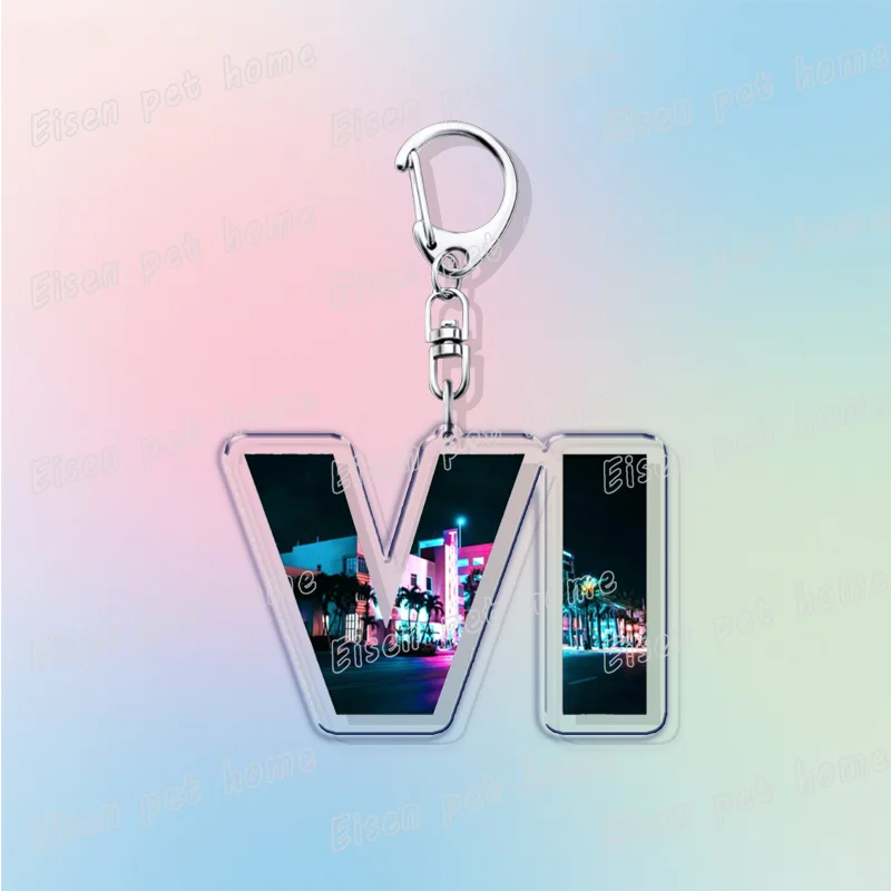 Silver keychain featuring a stylized V logo with neon city lights in the background