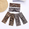 A set of four leopard print fashion headbands displayed on a white background.