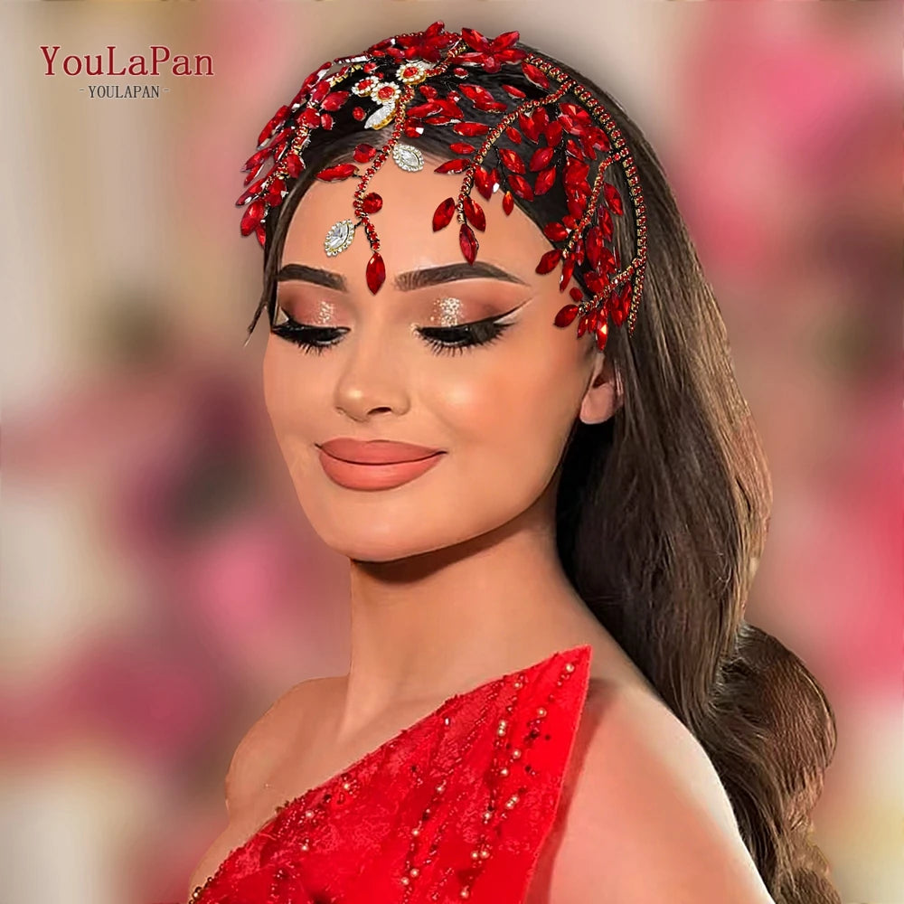 A woman wearing a red bridal hair hoop adorned with sparkling rhinestones and red floral accents.
