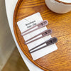 A set of vintage frosted geometry hair clips displayed on a white card on a wooden surface.