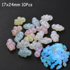 A collection of 10 translucent glow-in-the-dark acrylic beads in various shades of pink, yellow, and white.
