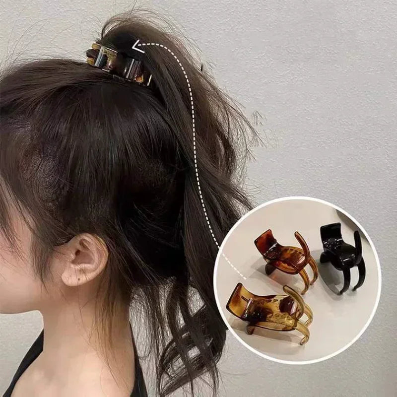 Transparent acrylic hair claw used to secure a ponytail or hair styling.