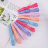 A set of professional multifunctional hair sectioning clips in various shades of pink, purple, and blue arranged on a white b
