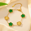 Gold plated stainless steel double-sided petal bracelet with green enamel accents on a cream background