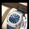 A close-up of a blue leather strap watch with a silver case and blue dial displayed in a light-colored box.