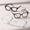 A display of three pairs of eyeglasses: black, tortoiseshell, and clear frames.