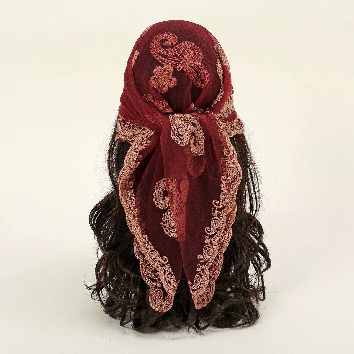 A deep maroon floral embroidered lace bandana headscarf tied around dark hair.
