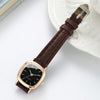 A brown leather watch with a gold-toned square face and a silver clasp resting on a white plate.