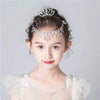 A young girl wearing a sparkling crystal princess tiara hair comb and crown