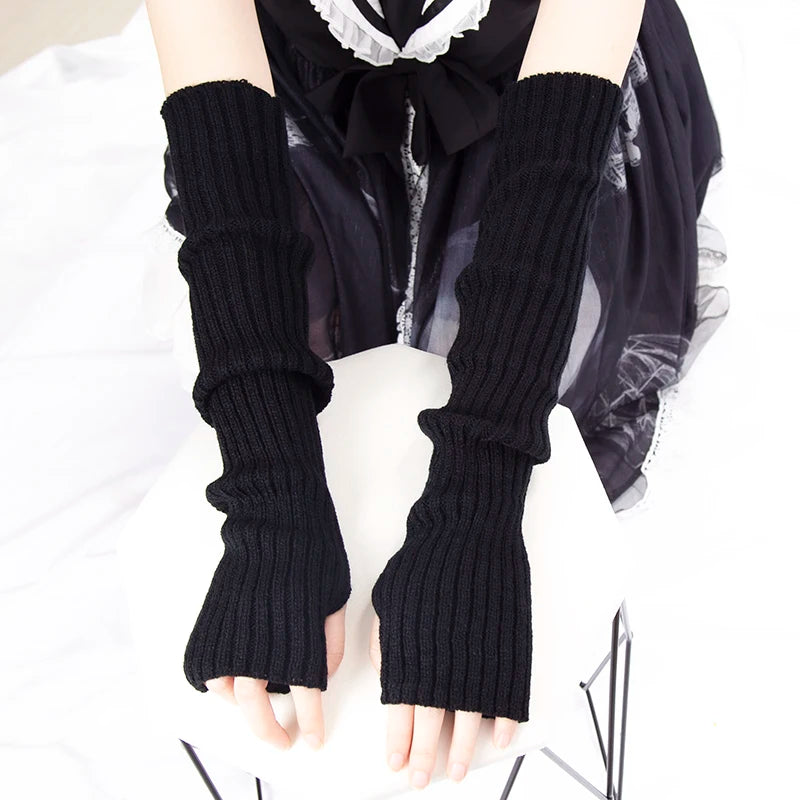 Black knitted fingerless gloves worn on a hand against a white background.