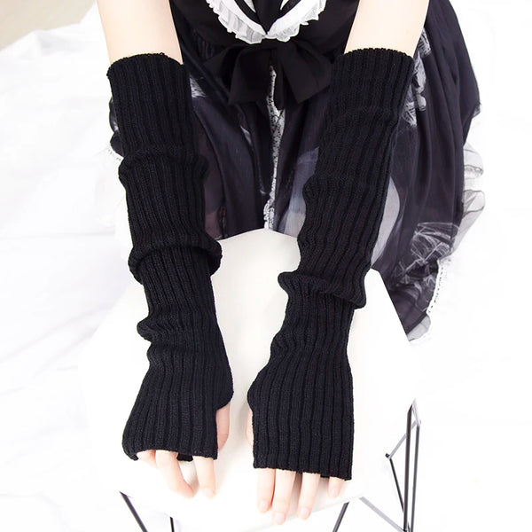 Black knitted fingerless gloves worn on a hand against a white background.