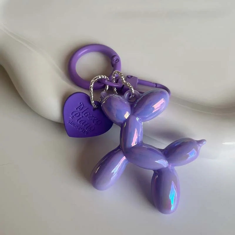 A purple jelly cartoon dog keychain with a purple ring and heart charm.