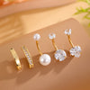 A set of five gold stainless steel dangled belly button rings featuring pearl and diamond accents.