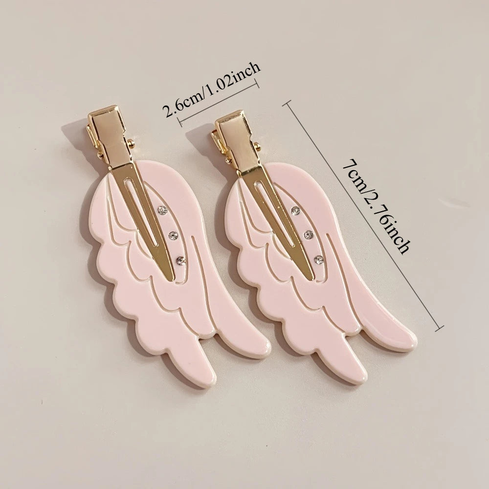 Pair of pink angel wing hair clips with gold barrettes and small rhinestones