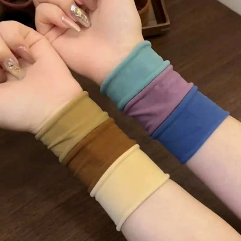 A person's wrist is shown wearing a stack of multi-colored elastic hair bands.