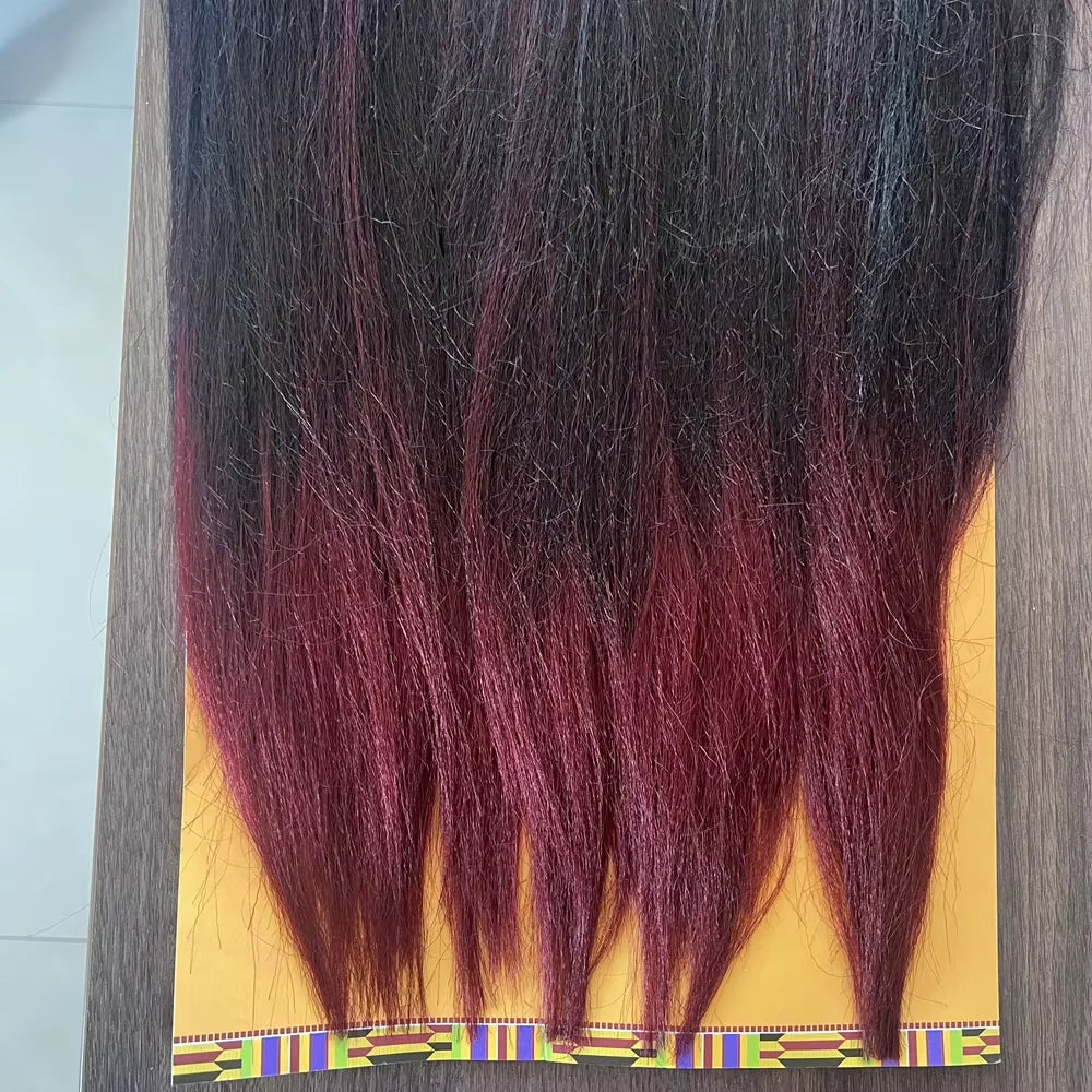 Langes dunkles Haar mit leuchtend rötlich-violetten Ombré-Spitzen vor gelbem Hintergrund.