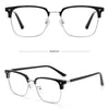 A pair of anti-blue light clear eyeglasses with black frames shown in a studio setting.