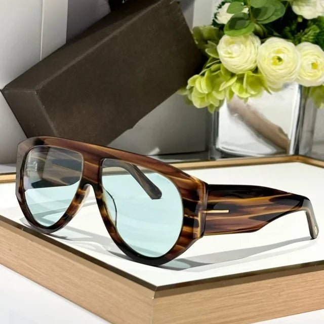 Brown tortoiseshell sunglasses with light blue lenses resting on a wooden frame.
