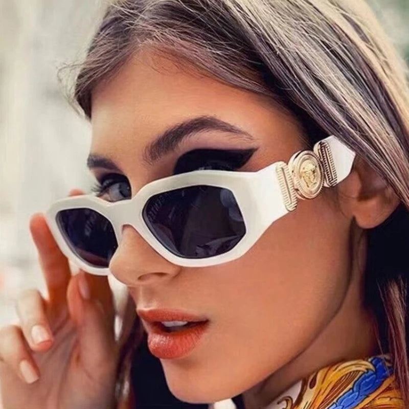 Eine Frau trägt weiße Vintage-Luxus-Square-Sonnenbrille mit goldenen Akzenten.